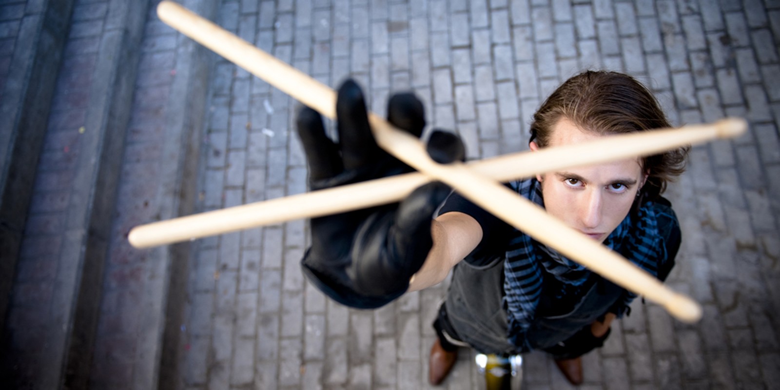 Schlagzeuger mit gekreuzten Sticks und Handschuhen