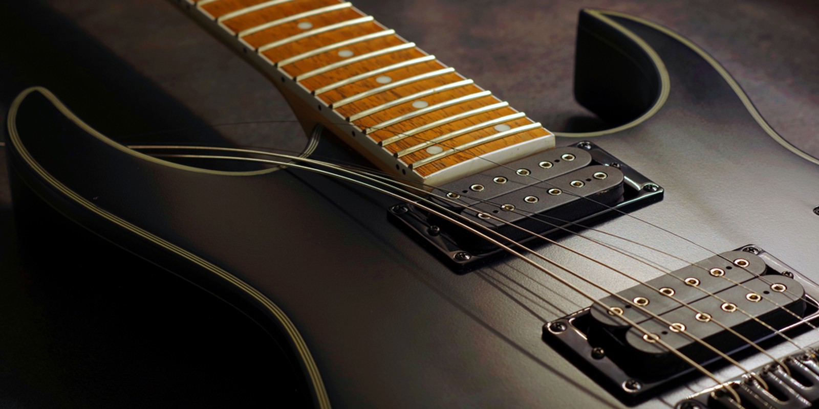 Saiten werden auf eine E-Gitarre aufgezogen