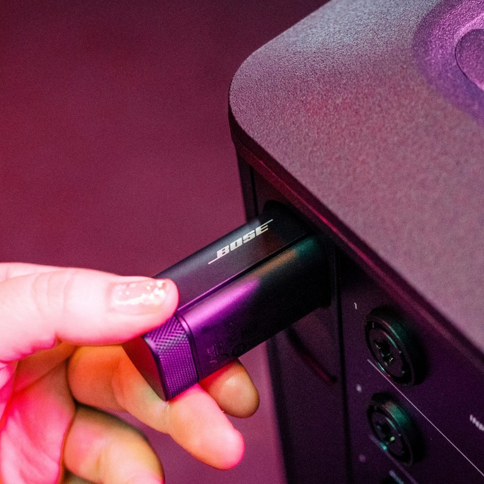 Transmitter wird in den Ladeschacht am Bose S1 Pro+ geschoben