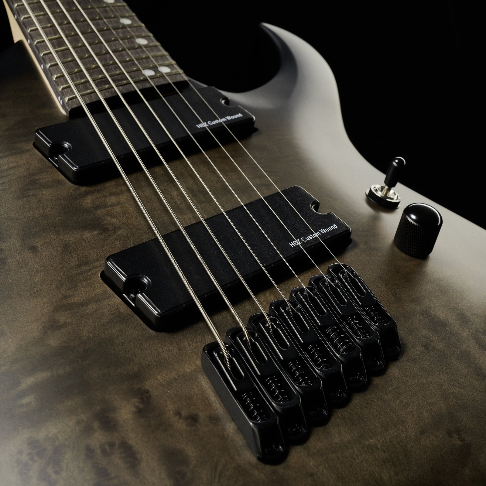 Nahaufnahme von Steg und Tonabnehmer der 7-Saiter Harley Benton MultiScale-7 BBB E-Gitarre