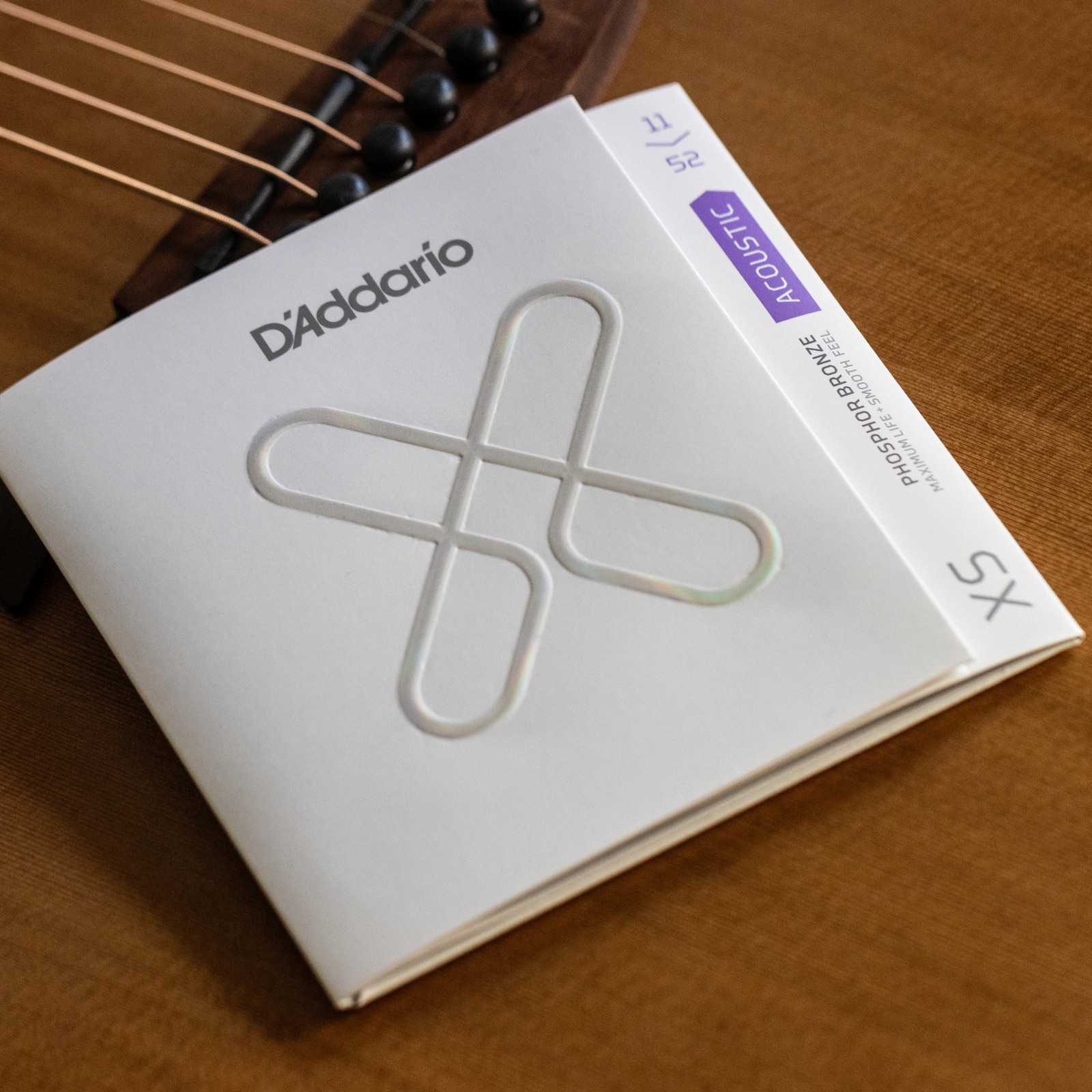D'Addario XSAPB1152, package pictured on an acoustic guitar